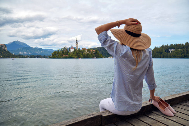 Young adult tourist woman enjoying barefeet on a lake wooden pier. - Foto, Imagen