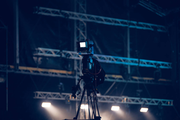 Luces y proyectores de escenario de concierto desenfocados con cámara para grabar el evento. - Foto, Imagen