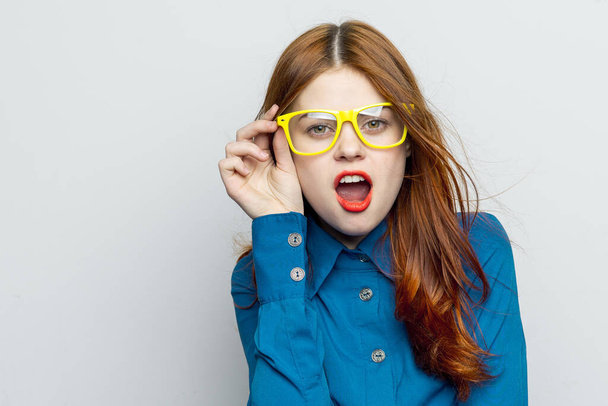 Business woman in blue shirt wearing yellow glasses emotions - Foto, afbeelding