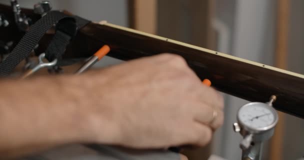 Gitarrenbauer montiert die akustische Gitarre auf der Jig in der Musikinstrumentenwerkstatt, 4k 60p 10 bit - Filmmaterial, Video
