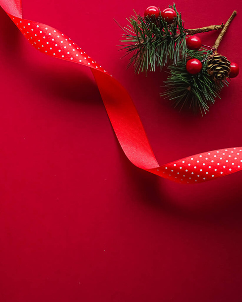 Vánoční ploché a prázdninový design koncept. Dekorace, ornament a vánoční dárek obal na červeném papíře pozadí jako plochý ležel horní pohled - Fotografie, Obrázek