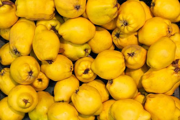 Lot of ripe yellow quince fruits ripened and harvested for sale in a shopping mall - Foto, Imagen