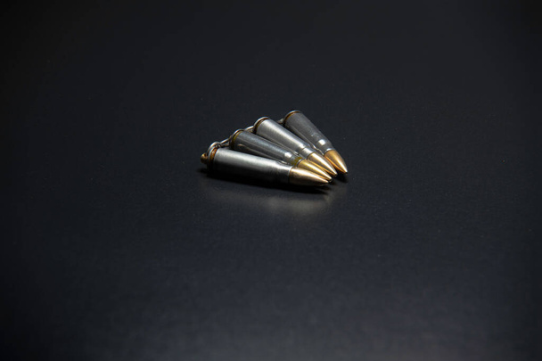 Kogel geïsoleerd op zwarte achtergrond met reflectie. Rifle kogels close-up op zwarte rug - Foto, afbeelding
