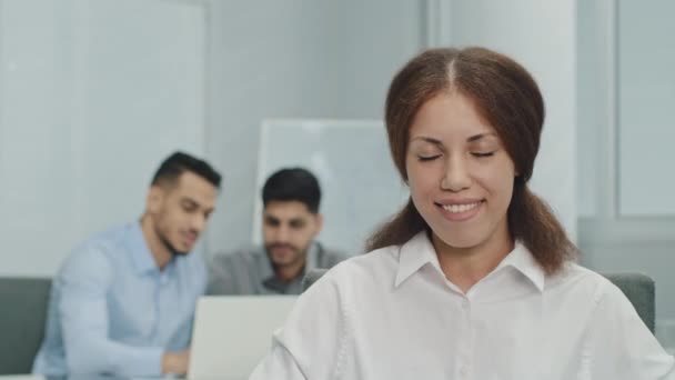 Friendly businesswoman making enthusiastic delight expression nods in agreement saying yes. Smiling female manager looking at camera in modern business office with multicultural professionals team - Footage, Video