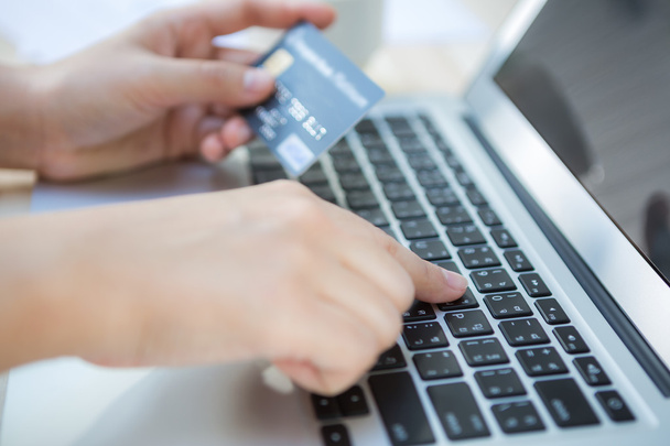 Hands holding a credit card and using laptop computer for online - Photo, image