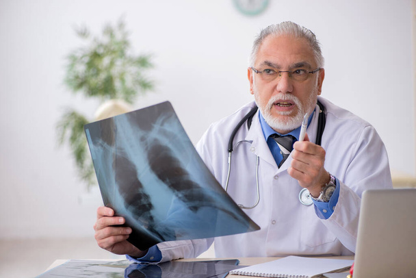 Old male doctor radiologist working in the clinic - Photo, Image