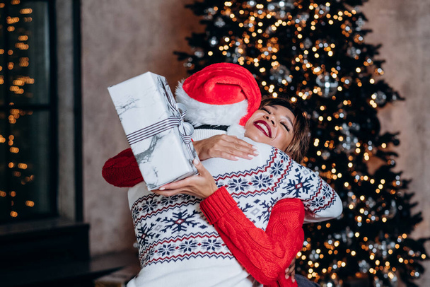 Jeune couple câlins après l'échange de cadeaux de Noël - Photo, image