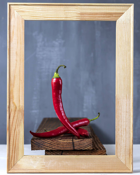 Red chilli pepper in frame on a dark stone background. Top view. - Foto, afbeelding