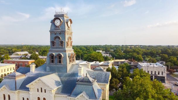 Widok z lotu ptaka zamyka Wieżę Zegarową na szczycie sądu hrabstwa Hood w historycznym Granbury Square w Teksasie. Tradycyjne zabytki w otoczeniu unikalnych butików, restauracji, bistro - Zdjęcie, obraz