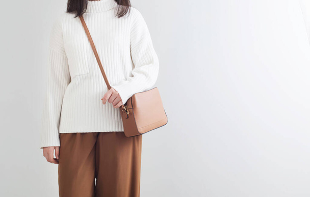 modern girl in white sweater and brown pants in white room - Foto, afbeelding