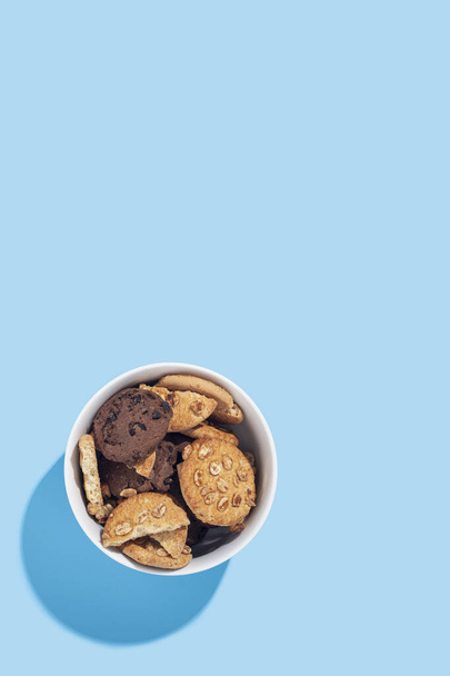 Hand made cookies in a white bowl on a light blue background. Top view, flat lay - Foto, immagini