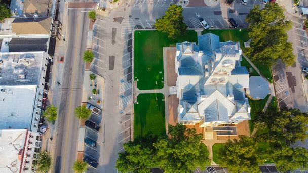 Saat Kulesi 'nin ve Downtown Square Granbury, TX, ABD' deki Tarihi Hood İlçe Adliyesi 'nin en üst görüntüsü. Yeşillik ve eşsiz butikleri, restoranları ve en büyüleyici küçük kasabası olan ziyaretçiler için oturma yerleri. - Fotoğraf, Görsel
