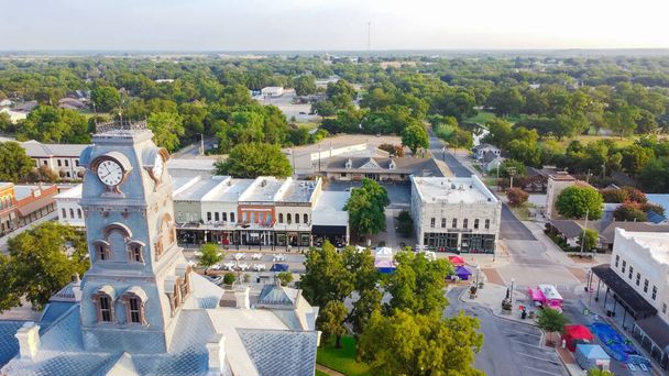 Widok z lotu ptaka Wieża zegarowa budynku sądu hrabstwa Hood w Downtown Square Granbury, Teksas, USA. Zielona ulica poziome tło od Shanley Park i dzielnicy mieszkalnej - Zdjęcie, obraz
