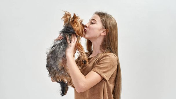 Caucasian girl hold and kiss Yorkshire Terrier dog - Foto, Imagem