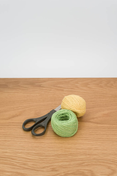 scissors and rough cotton decorative yarn on a wooden background with text space - Valokuva, kuva