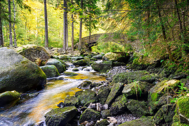 A beautiful scene with large stones in the Oker river bed and bridge in the background; Engagement islandin the Harz Mountains - Photo, Image