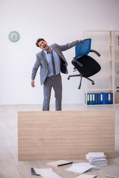 Jeune employé masculin effectuant des heures supplémentaires au bureau - Photo, image