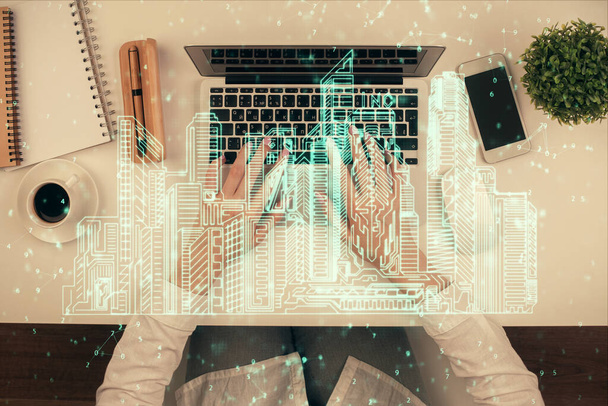 Double exposure of woman hands working on computer and buildings construction hologram drawing. Top View. smart city concept. - Фото, зображення