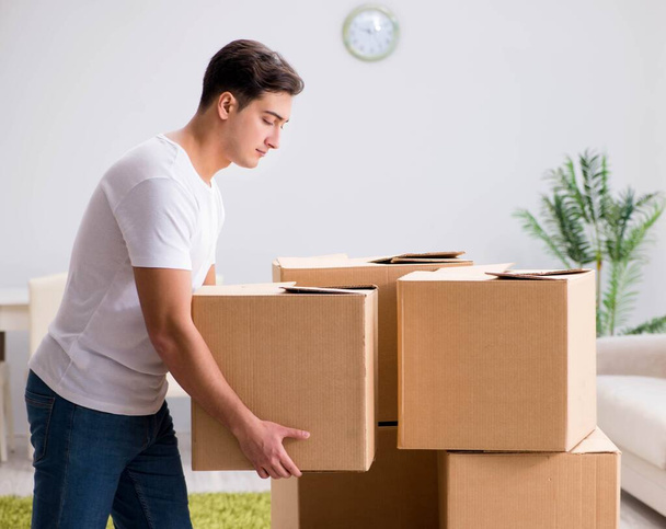 Hombre joven moviendo cajas en casa - Foto, Imagen