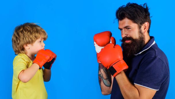 Дитина в боксерських рукавичках тренується з тренером. Тренер навчає хлопчика. Батько з сином боксу разом
. - Фото, зображення