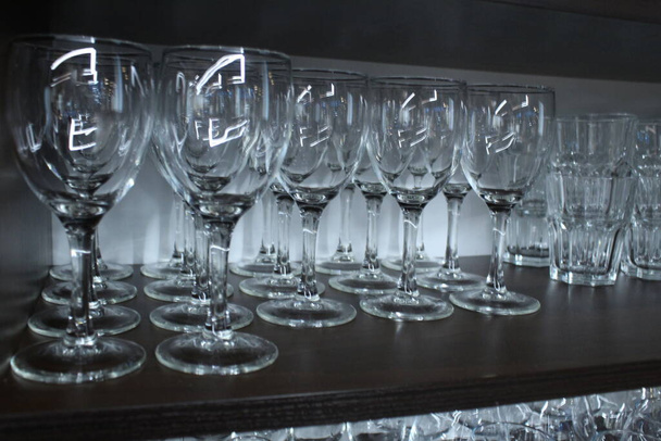 Очки стаканы чистые стоят в хранилище в ряд. Glassware. - Фото, изображение