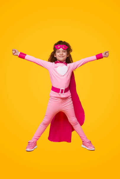 Excited superhero girl with arms raised - Fotó, kép