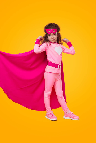 Girl in superhero costume showing muscles - Valokuva, kuva