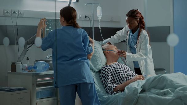 Wieloetniczny personel medyczny pomagający chorym pacjentom - Zdjęcie, obraz