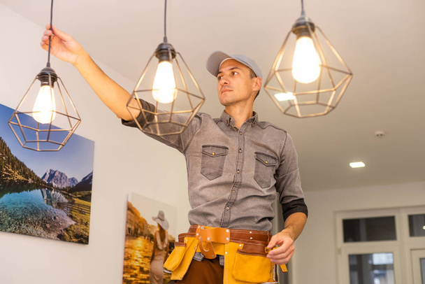 İşçi evin tavanına lamba yerleştiriyor. Metin için boşluk - Fotoğraf, Görsel