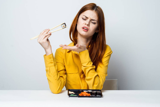 woman at the table eating sushi restaurant japanese snack - Foto, Imagen