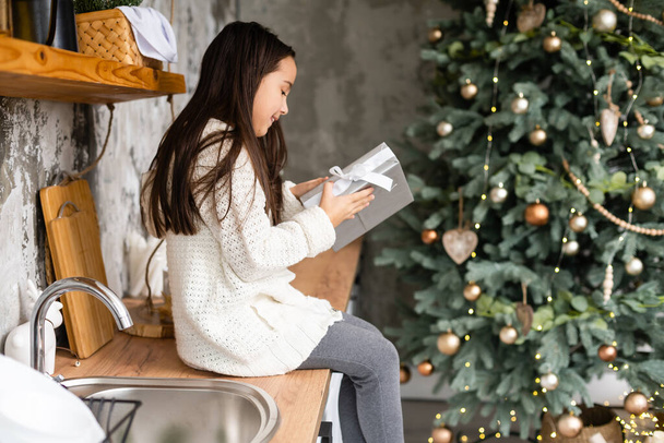 Mutlu, küçük, gülümseyen kız Noel hediyesi kutusuyla. - Fotoğraf, Görsel