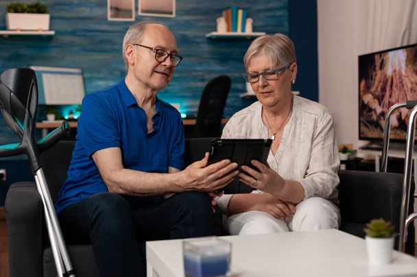 Rentner und Frau halten digitales Tablet zusammen - Foto, Bild