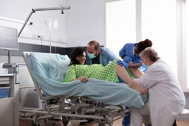 Equipo médico multiétnico que ayuda con el parto infantil - Foto, Imagen