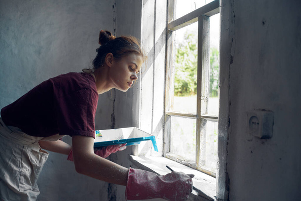 woman painter paints window with brush renovation interior decoration - Fotografie, Obrázek