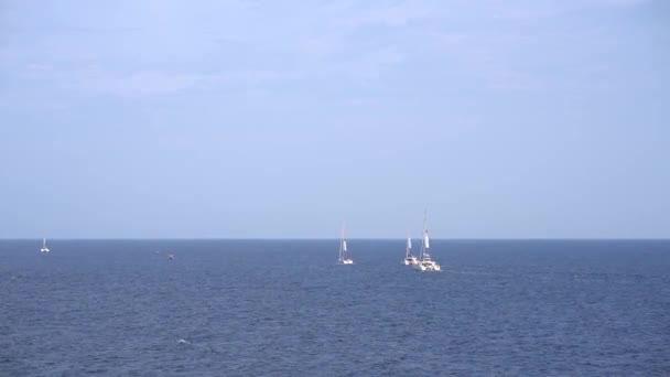 Zeilboten drijven op de open zee tegen de blauwe lucht - Video