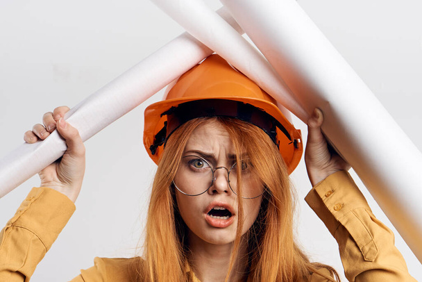 female engineer in orange hard hat blueprints architect - Foto, immagini