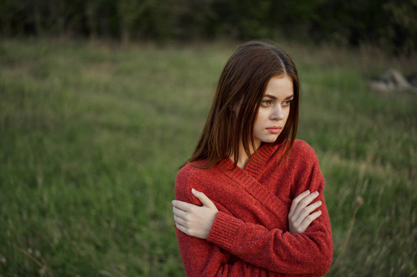 woman in a red sweater outdoors in a field walk - 写真・画像