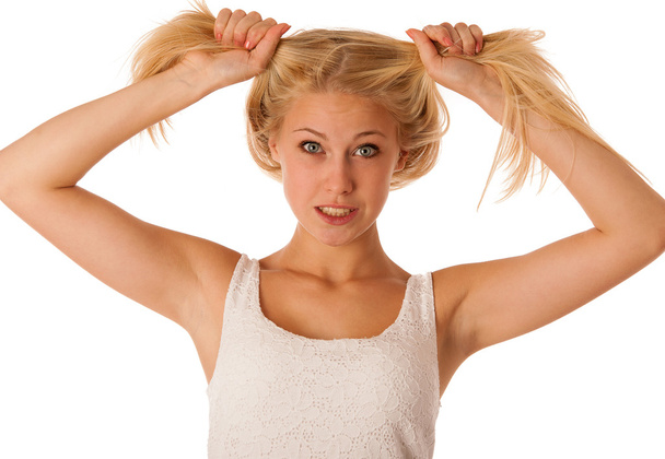 Beautiful young blonde woman holds hair in her hand gesturing ex - Fotoğraf, Görsel