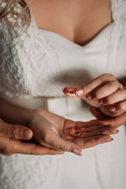 Gentle embrace of the hands of the newlyweds with wedding rings. - Foto, imagen