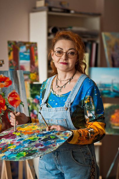 Portrait of an artist with a lot of experience on the background of the study. - Photo, image