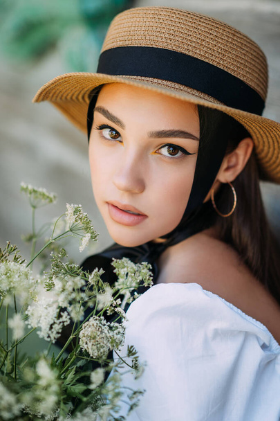 A large young female portrait in a hat and with black ribbons. - Foto, Imagen