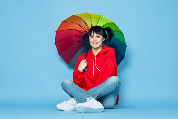 cheerful woman in red t-shirt rainbow color umbrella fashion - Foto, afbeelding