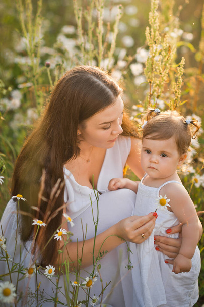 Mother and daughter in a field of dandelions. - Фото, изображение