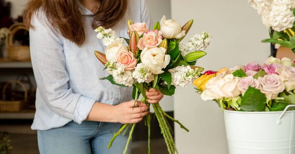 Small business. Female florist in flower shop. Floral design studio, making decorations and arrangements. Flowers delivery, creating order  - 写真・画像