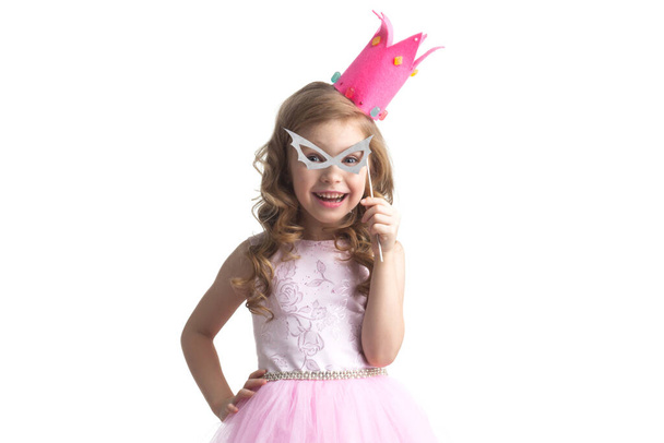 Funny princess girl in pink dress and crown holding party glasses on stick isolated on white background - Foto, Imagen