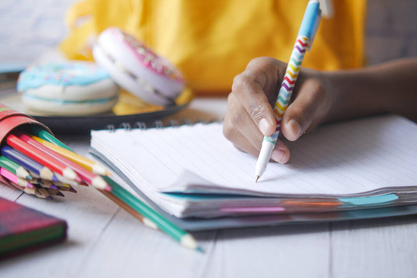 child hand writing on notepad  - Foto, Imagen