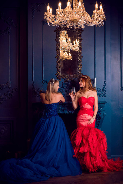 Due donne in abito di lusso rosso e blu, vigilia di Natale, abiti di ispirazione per la festa, collezione di abiti da sera - Foto, immagini