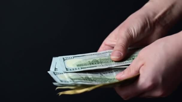 Beim Zählen von Hundert-Dollar-Scheinen zählen Geschäftsleute Geld, Geld auf schwarzem Hintergrund. - Filmmaterial, Video