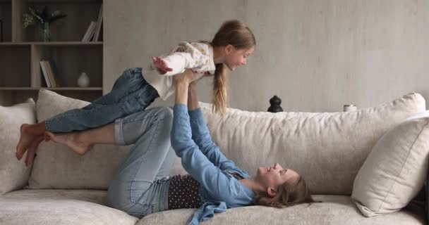 Overjoyed preteen daughter fly being lifted up on mother hands - Felvétel, videó
