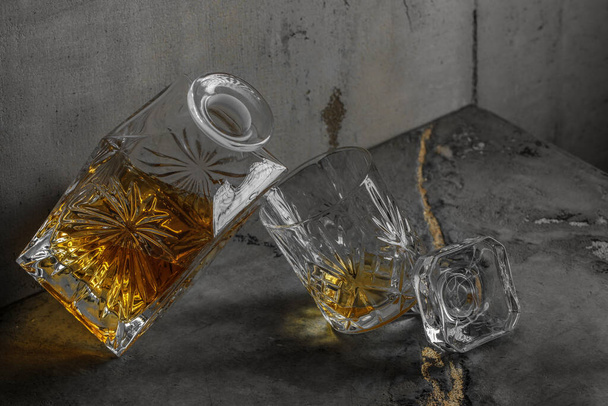 Glass of the whiskey with a square decanter on a grey clay textured  background. - Fotografie, Obrázek